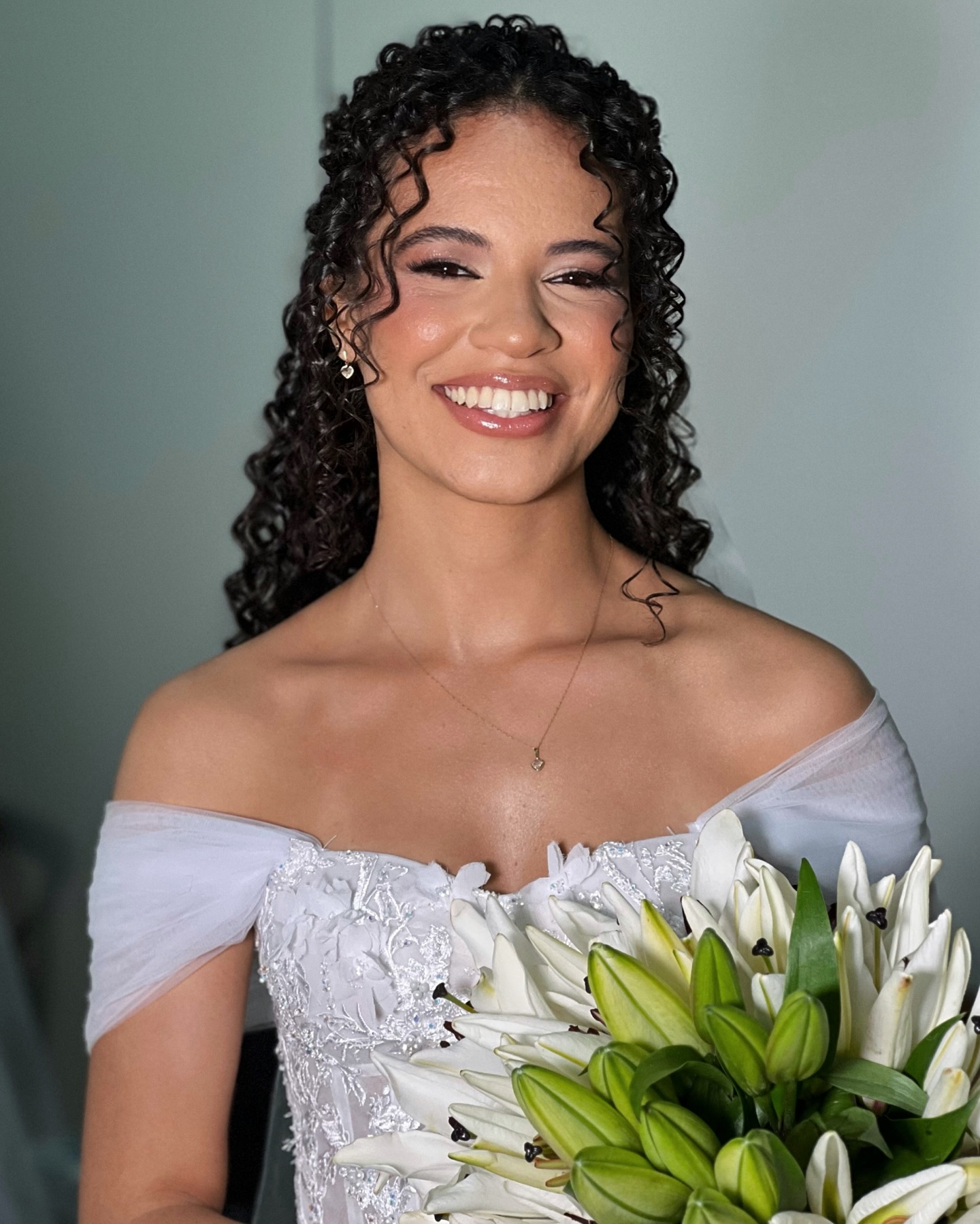 Cliente sorrindo com maquiagem natural e pele iluminada, assinada por Gabriela Junqueira